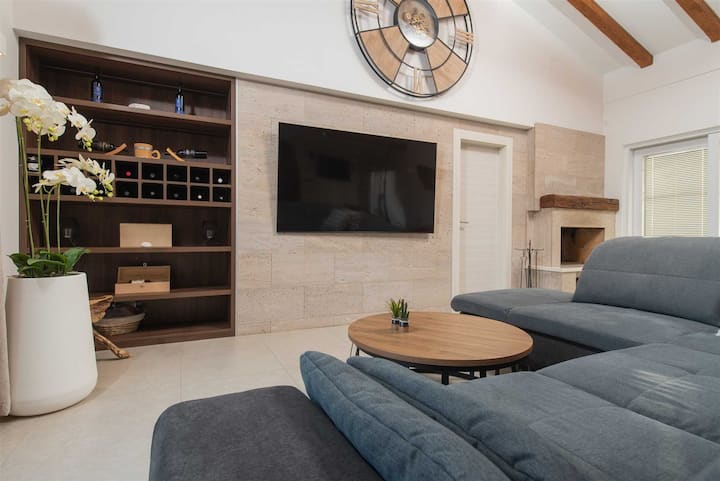 Sala de estar con chimenea, sofá, televisión de pantalla plana y aire acondicionado.