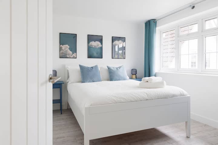 Chambre sereine avec art mural sur le thème des nuages et accents bleus doux pour une atmosphère de rêve