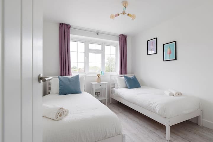 Chambre avec lits jumeaux et décoration lumineuse et literie confortable