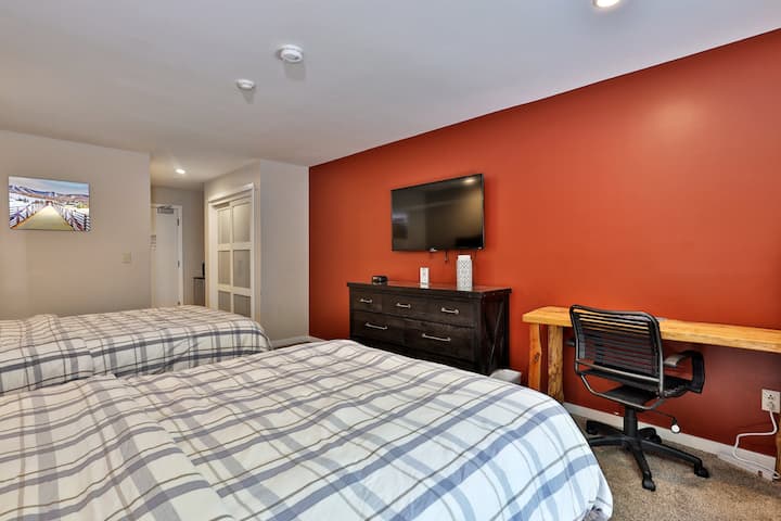 Útulné štúdio v štýle hotelovej izby v Killington Center Inn & Suites vo Vermonte. Po dni lyžovania alebo iných dobrodružstiev si oddýchnite na dvoch manželských posteľiach a oddýchnite si pri inteligentnej televízii. V prípade potreby je k dispozícii písací stôl so stoličkou a vysokorýchlostným Wi-Fi pripojením.