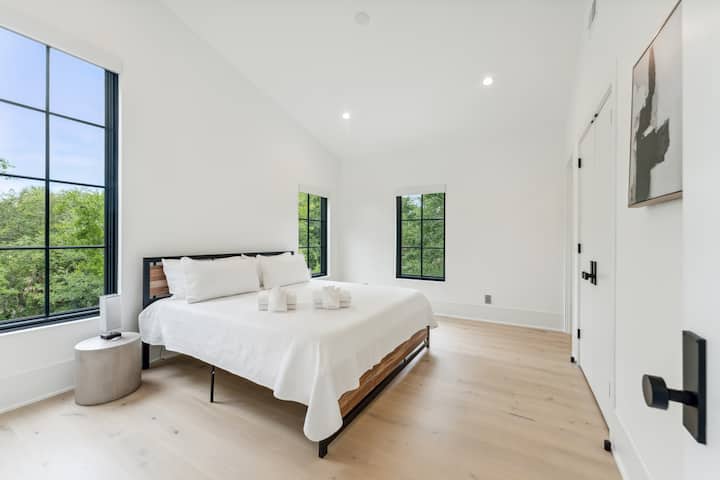 Pobrežná spálňa s manželskou posteľou king, vlastnou kúpeľňou a veľkými oknami s prirodzeným svetlom