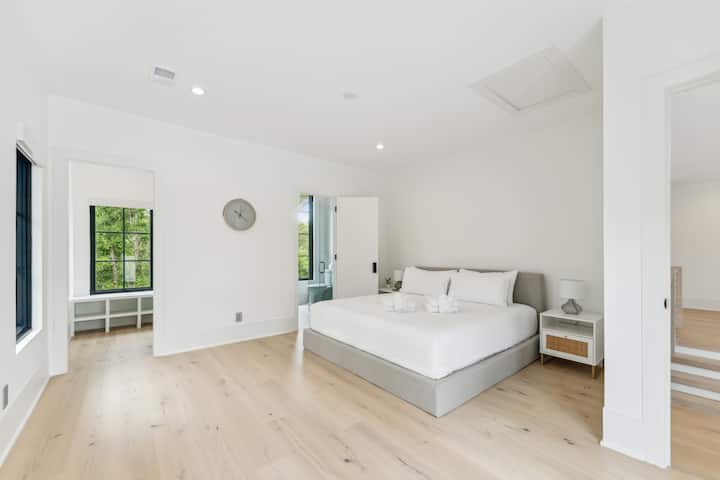 Relaxačná moderná spálňa v pobrežnom štýle s manželskou posteľou veľkosti King, vlastným balkónom a sprchovacím kútom so sklenenými stenami v pokojnom prostredí – len pár krokov od pláže