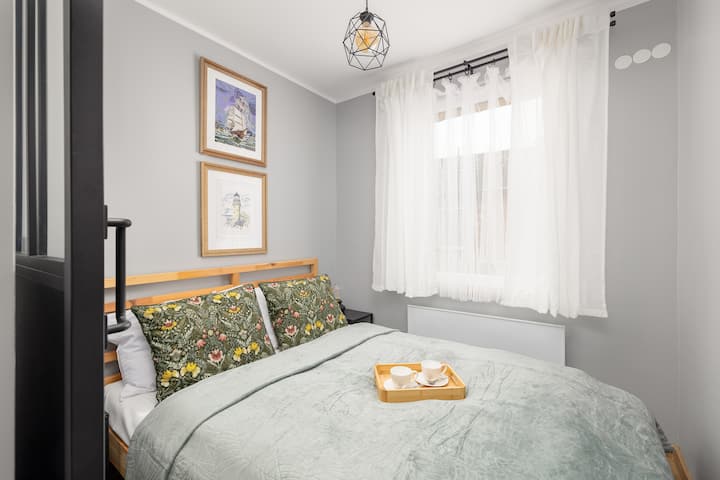 Მყუდრო საძინებელი დეკორატიული ბალიშებითა და რბილი საწოლის გადასაფარებლით საღამოს დასვენებას იწვევს.