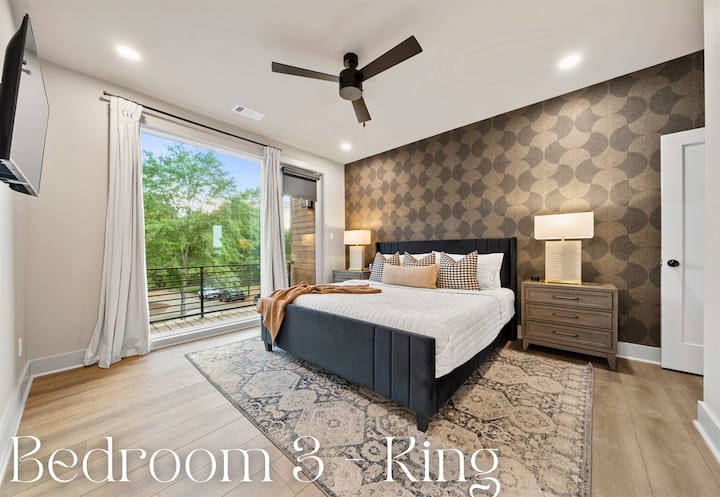 The king-sized bed, dressed in luxurious bedding and complemented by chic pillows, exudes comfort and elegance.