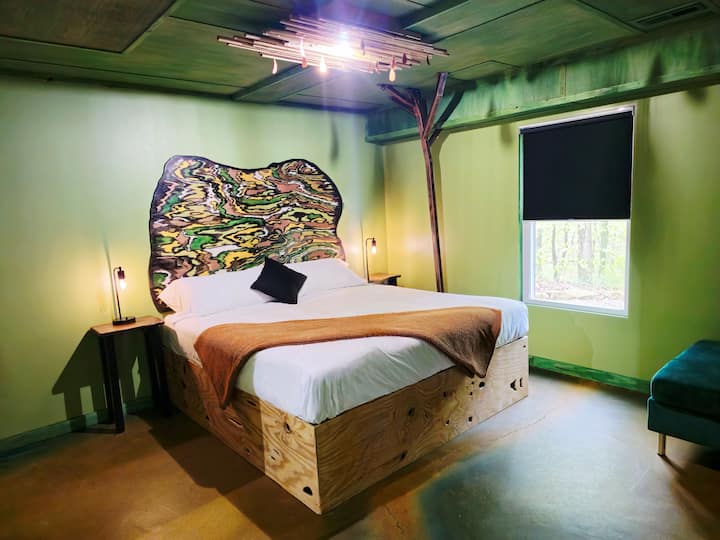 Kjo dhomë gjumi moderne dhe eklektike në katin e poshtëm ka një krevat dopio "king", një krevat me rrota në dollap, një kënd leximi dhe një hapësirë pune për tavolinën e punës.