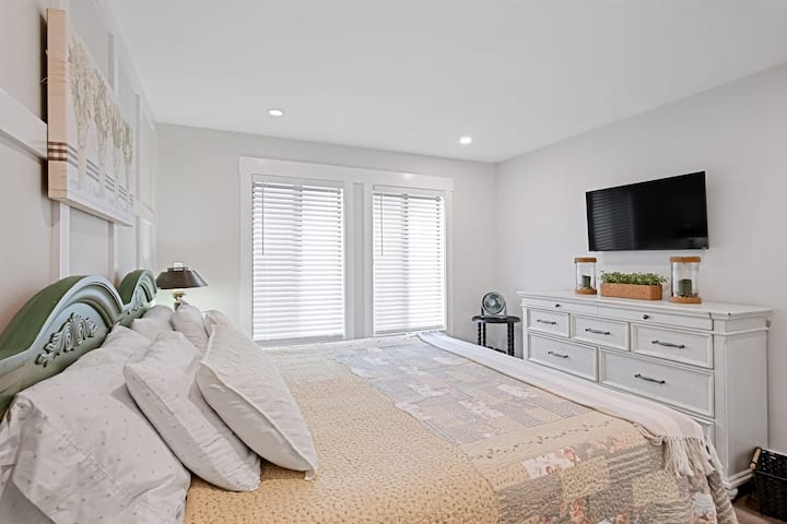 Bedroom 1 with King bed and private bathroom. It also has a large dresser and closet. The windows overlook the main pool. 