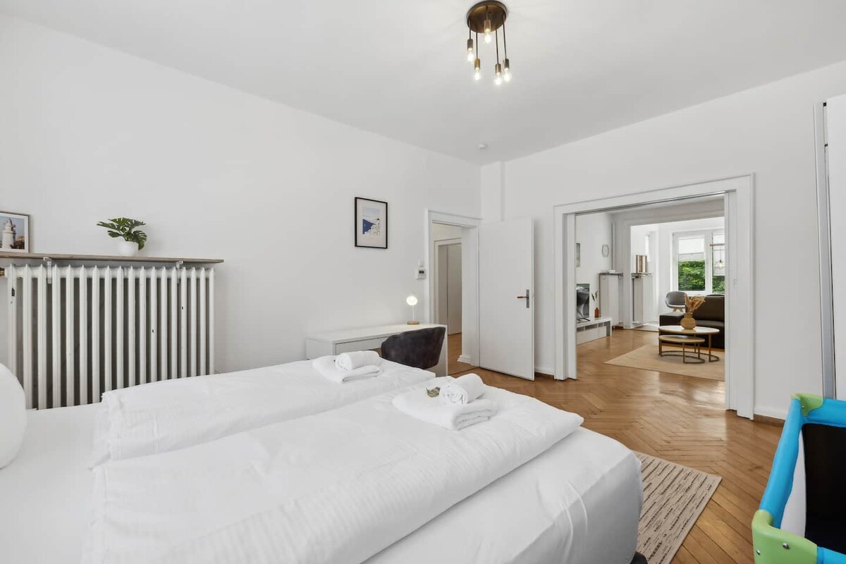 غرفة نوم واسعة بسرير مزدوج ومنطقة عمل وإمكانية الوصول المباشر إلى غرفة المعيشة.