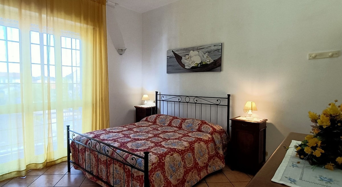 Een slaapkamer met uitgang naar het balkon en airconditioning in corrodio, maar met uitzicht op de kamer, om het goed af te koelen.