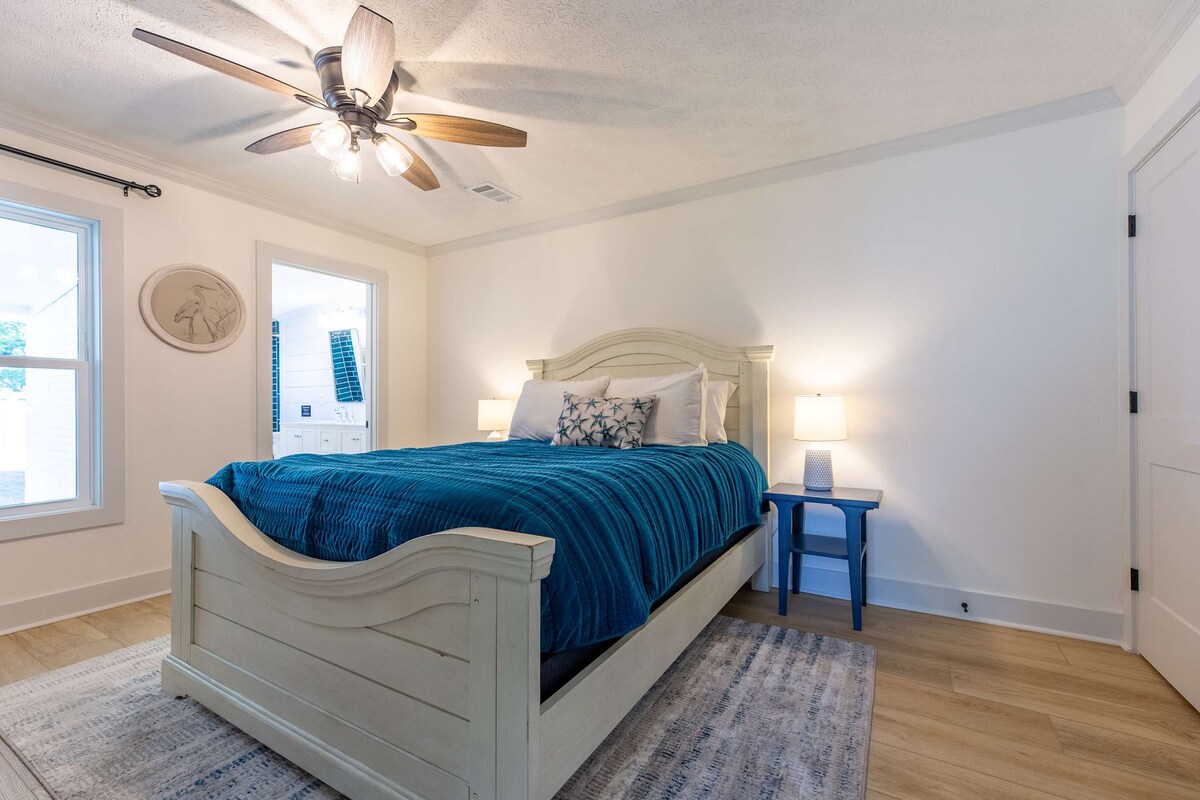 غرفة نوم بحجم كوين مع حمام داخلي خاص. يتميز بلوحة ألوان ساحلية ناعمة وفراش مريح وأجواء هادئة.