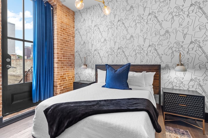 ห้องนอนที่สองมีเตียงควีนไซส์ที่อบอุ่นตู้เสื้อผ้าสมาร์ททีวีและผ้าปูที่นอนนุ่มๆ ห้องพักนี้เหมาะสำหรับครอบครัวหรือเพื่อนที่เดินทางด้วยกันผสมผสานความสะดวกสบายและความเป็นส่วนตัวใจกลางเมืองนิวออร์ลีนส์