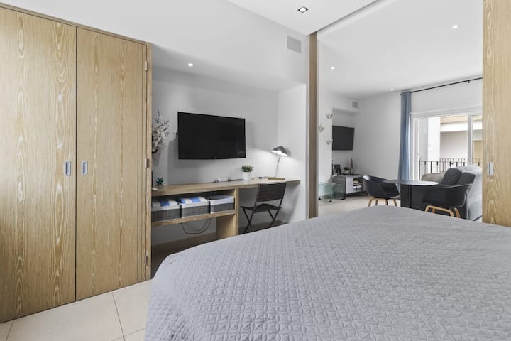舒适的卧室配有智能电视、专用工作空间和充足的衣柜