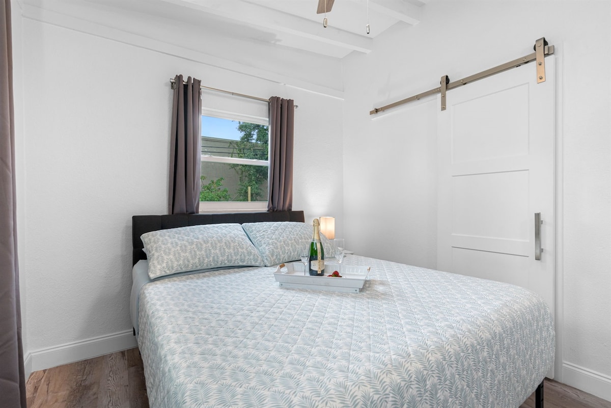 חדר השינה המקסים הזה כולל מיטת קווין סייז מפוארת המעוטרת במצעים וכריות איכותיים.