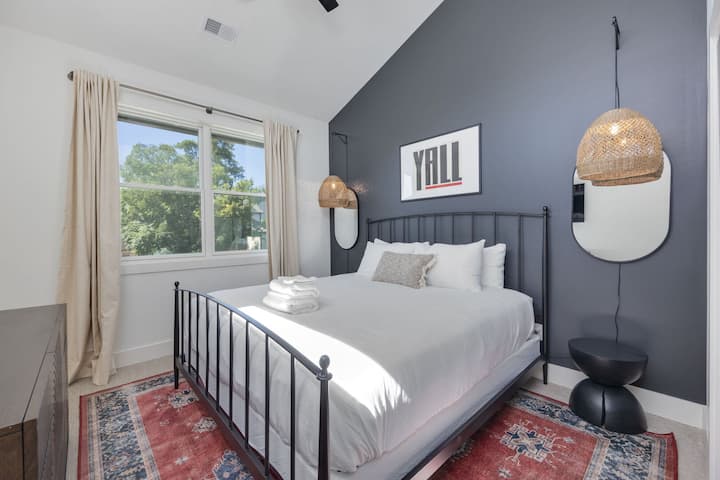 היחידה העליונה - קומה 2: חדר שינה 3 עם מיטת קינג סייז, מרחב ארונות, טלוויזיה חכמה ותקרה גבוהה מקומרת.