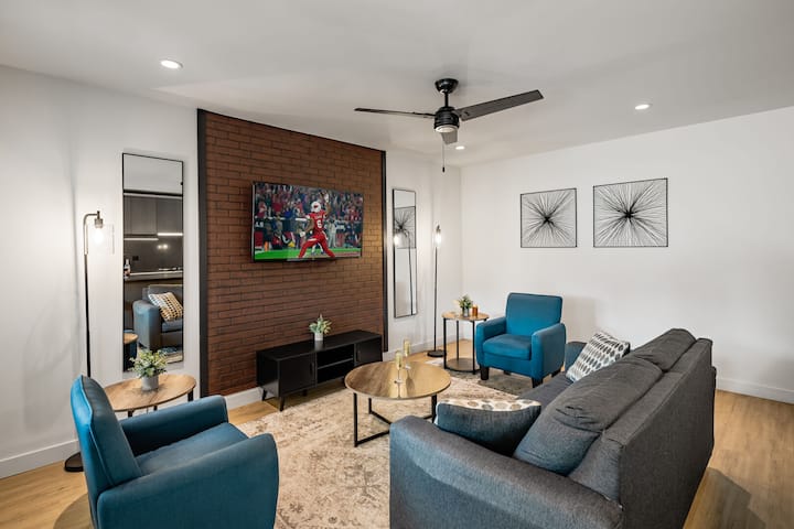 Warmes und einladendes Wohnzimmer mit einem Smart-TV für Unterhaltung und Designermöbeln mit einem Schlafsofa, das in ein Queensize-Bett umgewandelt werden kann.