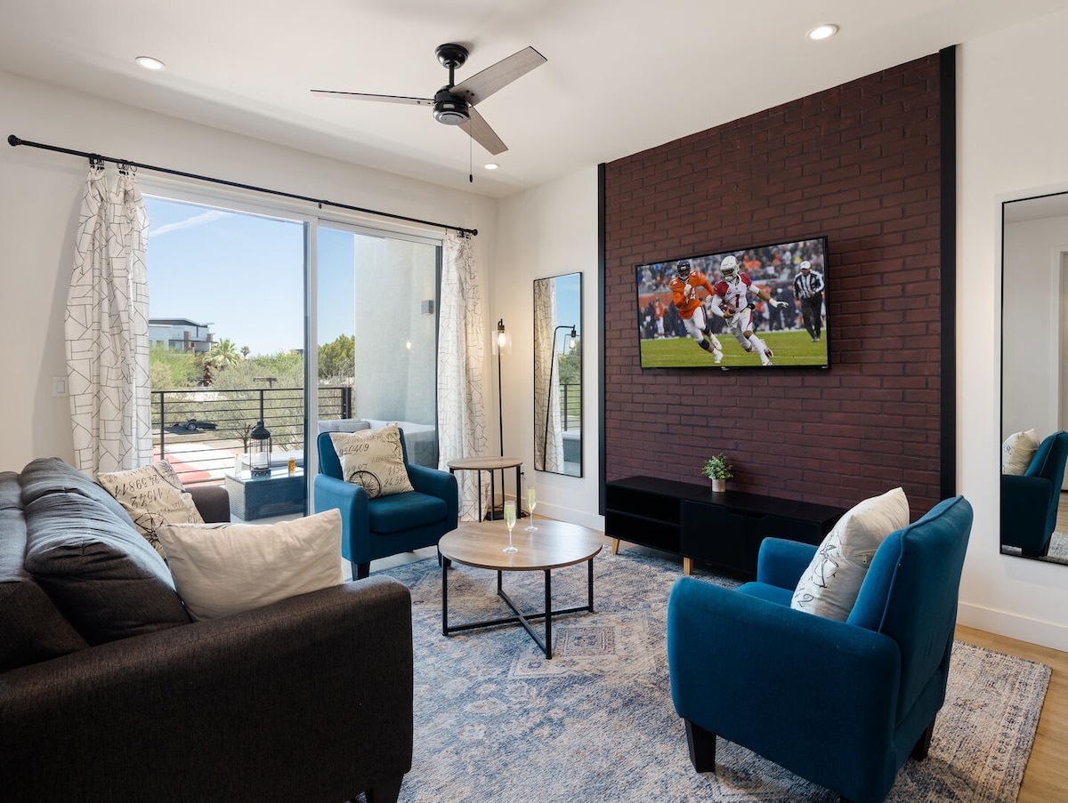 Primer piso: sala de estar cálida y acogedora con un televisor inteligente para el entretenimiento y muebles de diseño que incluyen un sofá cama que se convierte en una cama tamaño queen.