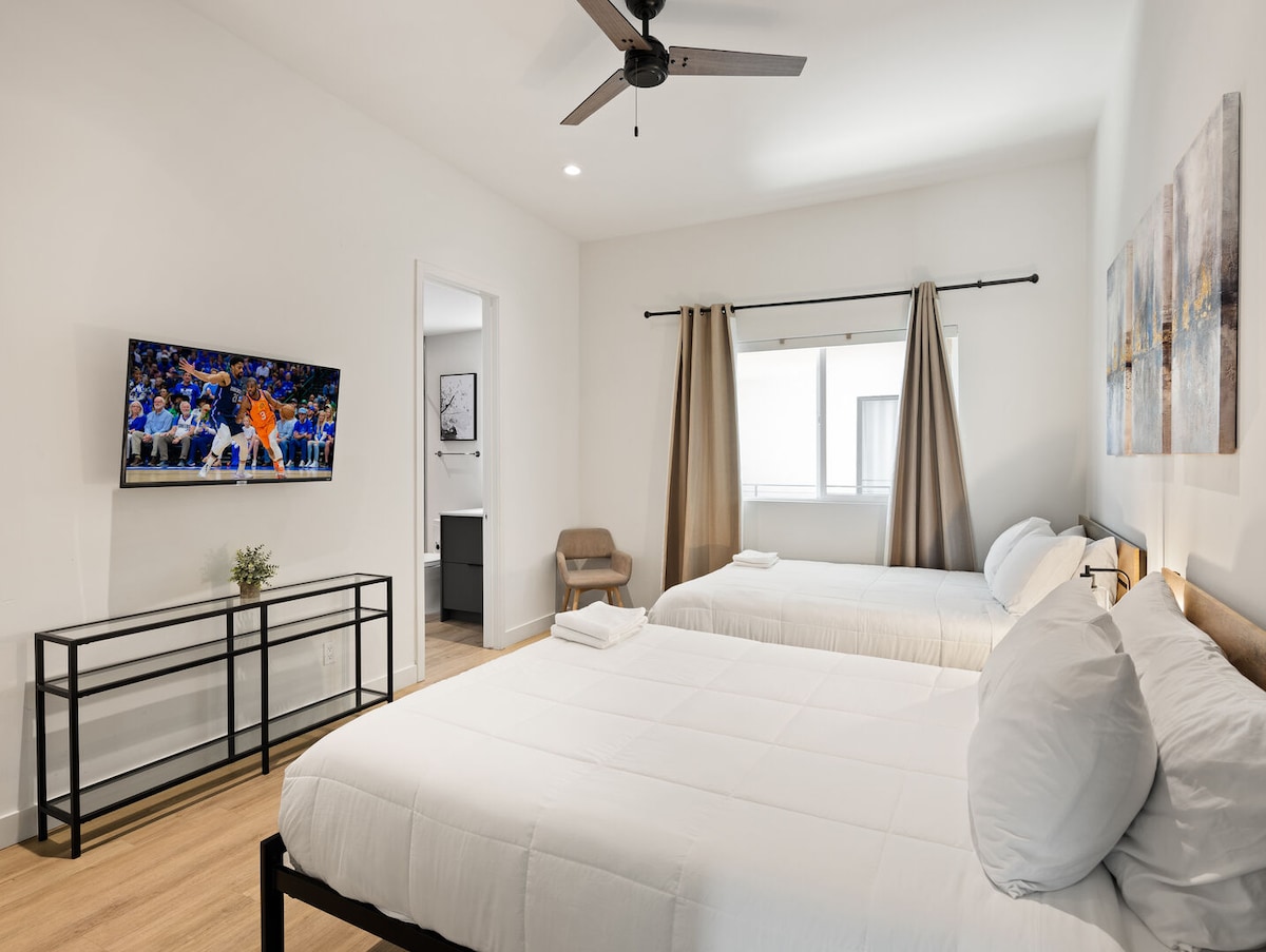 Segundo piso: segundo dormitorio con 2 camas queen, un televisor inteligente y un baño privado.