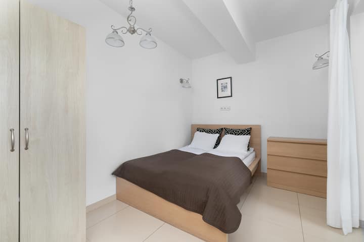 Dormitorio luminoso con una cama grande y cortinas blancas.