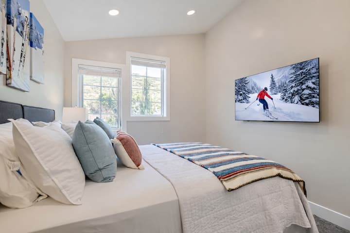 Détendez-vous dans cette chambre confortable avec des draps doux, une vue sur la montagne à travers des fenêtres lumineuses et une grande télévision pour votre divertissement.