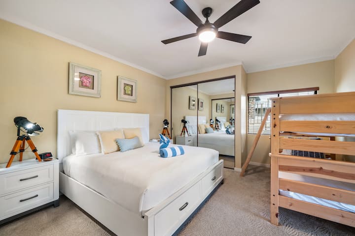 Un dormitorio apto para familias con una cama tamaño queen y literas, ideal para estadías para niños o grupos, que ofrece comodidad y conveniencia en este alquiler vacacional.
