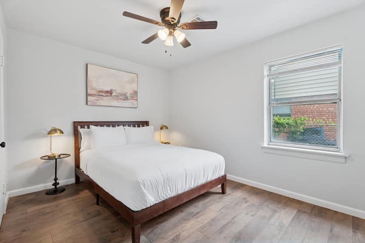 חדר אלגנטי עם מיטת קווין סייז, תאורה חמימה ומצעים רכים — מקום המפלט השקט שלכם אחרי יום בחוץ.