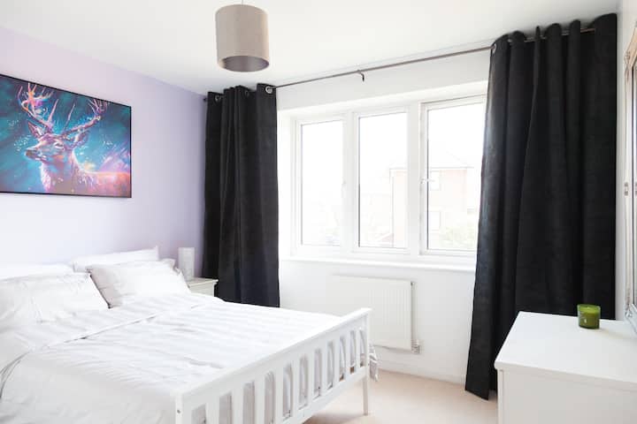 غرفة النوم الثانية، مفروشة بطاولات بجانب السرير ومصابيح جانبية للسرير وصندوق من الأدراج لمساعدتك في الحصول على إقامة مريحة.