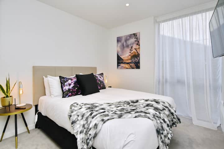 Slaapkamer 1 heeft een queensize bed en een tv