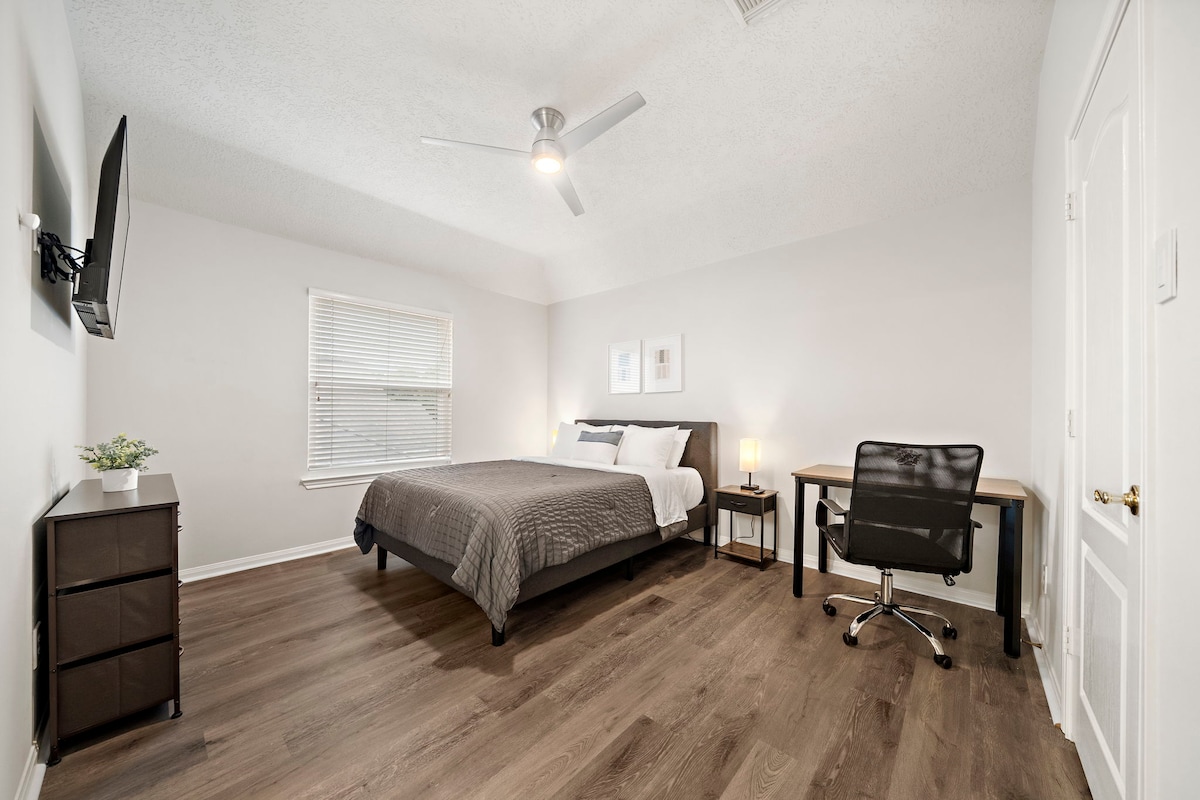 Dhoma e dytë e gjumit me një krevat dopio "queen" dhe një hapësirë pune të dedikuar.