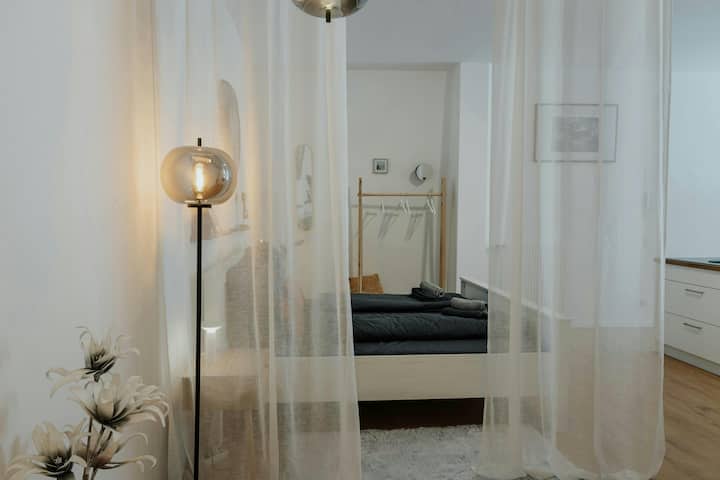 Დიდი საწოლი, რომელიც გამოყოფილია სუნთქვადი ფარდებით.