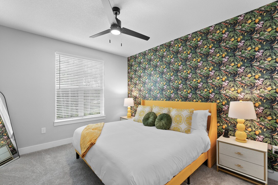 这是一间明亮而现代化的卧室，配有大胆的装饰墙