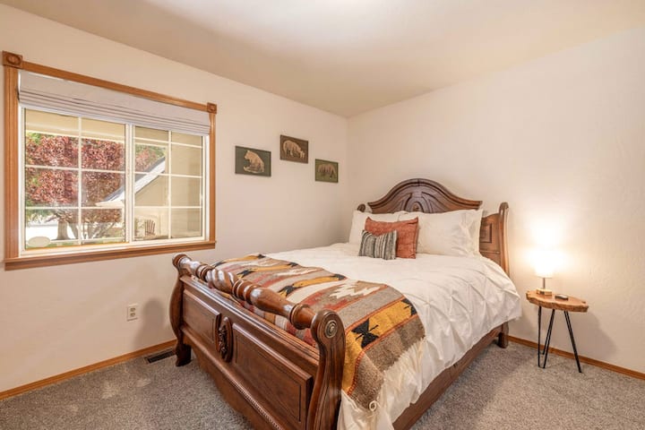 Otro dormitorio acogedor con una cama tamaño queen y ventanas que dan a hermosas vistas del tranquilo vecindario.