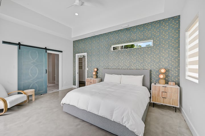 Povucite se u luksuzni apartman Primary s elegantnim bračnim krevetom, mirnim obalnim ukrasnim detaljima i elegantnim vratima koja vode do privatne kupaonice nalik spa-centru.