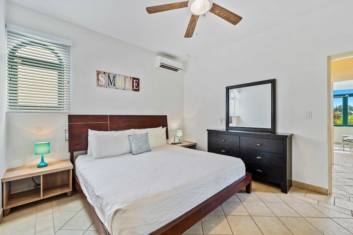 - Просторен брачен кревет со елегантна дрвена табла
- Во собата има голем гардеробер со огледало, кој обезбедува простор за складирање и место за подготовка
- Клима уредот обезбедува удобност, додека веселиот ѕиден декор „НАСМЕВКА“ додава позитивен шмек