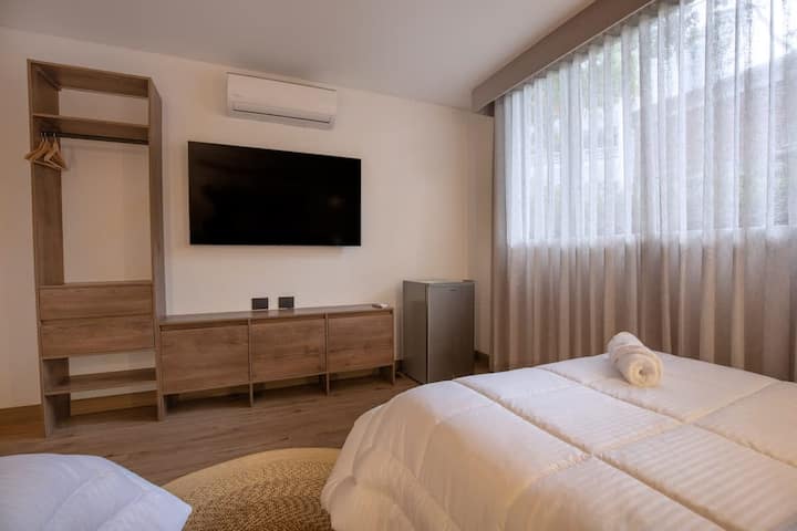 Pumzika kwa mtindo katika chumba hiki chenye vitanda viwili kilicho na Televisheni mahiri iliyowekwa ukutani, mapazia ya kuzima na fanicha ndogo. Sehemu nzuri ya kupakia upya au kutazama vipindi unavyopenda.  ️ ❄️
