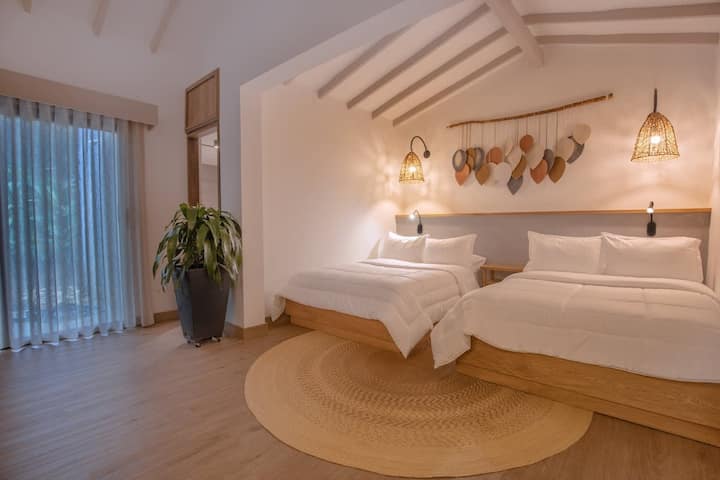 Ikiwa na vitanda viwili, dari za juu, na kijani kilichopandwa kwenye chungu, chumba hiki cha kutuliza ni kizuri kwa makundi. Furahia muundo laini, sanaa ya ukuta iliyopangwa na bafu la kujitegemea kwa ajili ya starehe ya juu. ️✨

