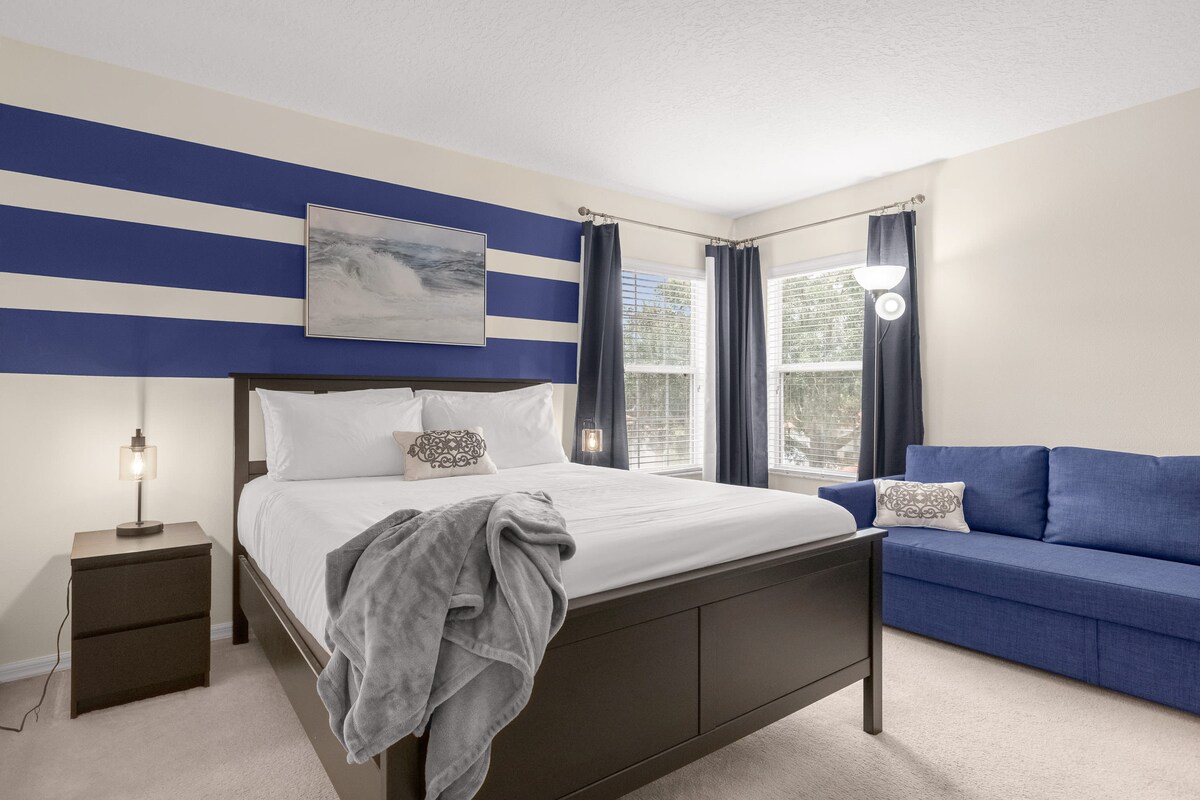 Modern Bedroom With Blue And White Accents And Extra Seating