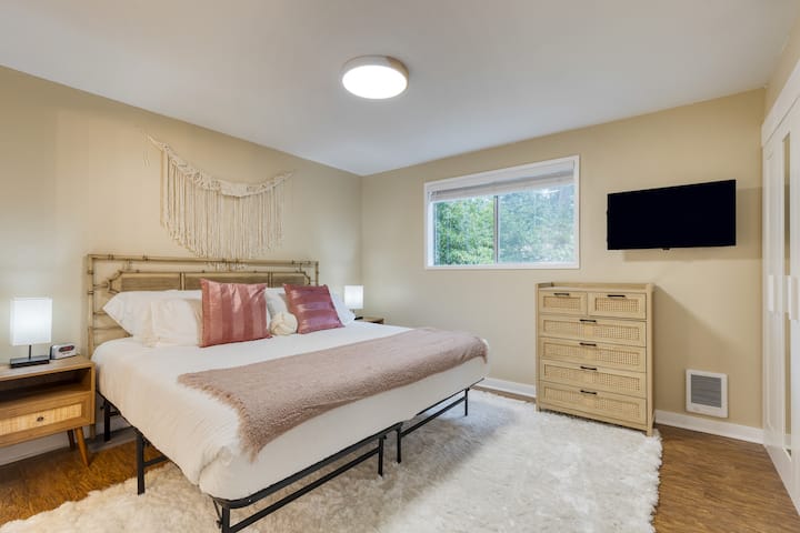 Chumba cha kulala cha msingi kina kitanda aina ya king, televisheni na bafu la malazi.