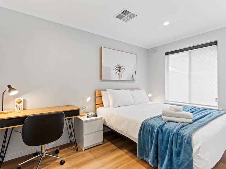 Dormitorio principal con escritorio de trabajo y silla de oficina de altura ajustable.