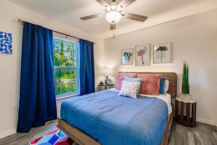 Jednotka 17428: Útulná spálňa s manželskou posteľou, posteľnou bielizňou a žiarivými akcentmi. Veľké okno so závesmi, stropný ventilátor a moderná výzdoba vytvárajú príjemnú atmosféru na oddych.