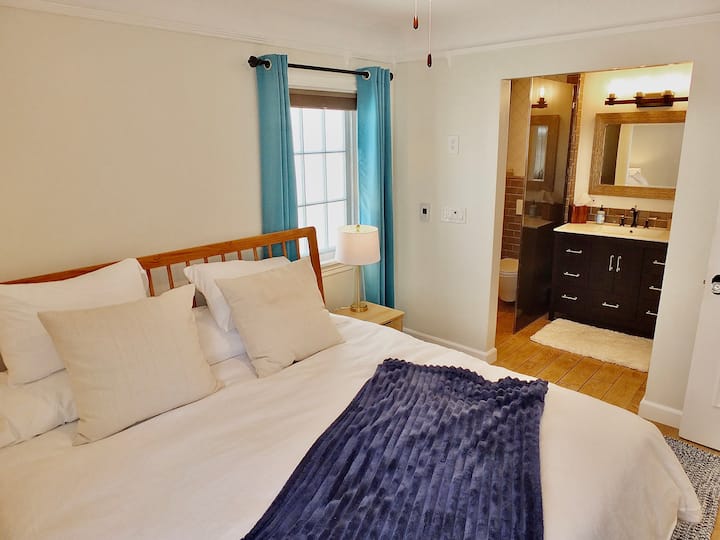 The tranquil master suite boasts a plush king bed & private ensuite