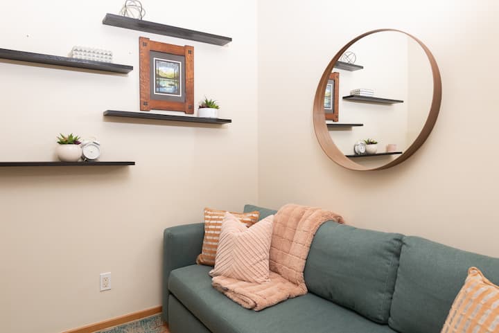 - Snuggle into this quiet lounge nook, perfect for reading, journaling, or a midday nap
- Decorated with minimalist shelves, soft textiles, and warm lighting
- Peaceful corner designed for recharge, reflection, and comfort