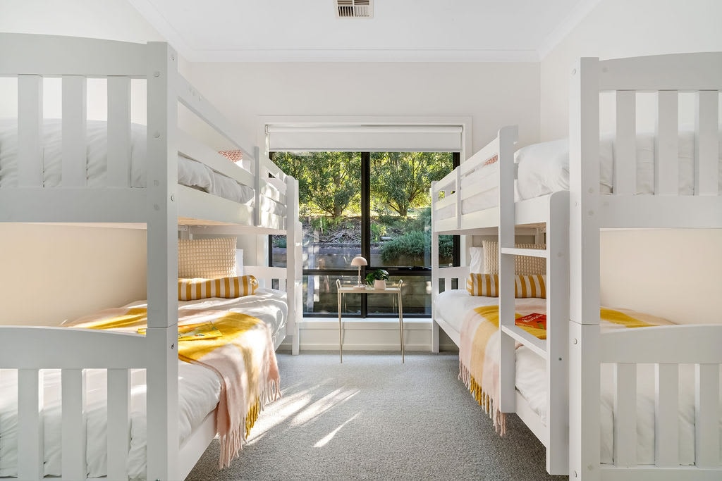 الغرفة المكونة من طابقين، التي تحتوي على أربعة أسرّة مفردة وخزانة ملابس