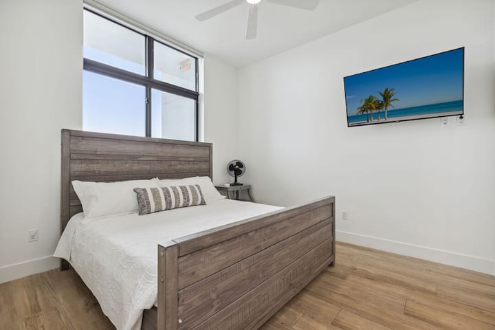 Gezellige slaapkamer met een kingsize bed en een gemonteerde smart-tv