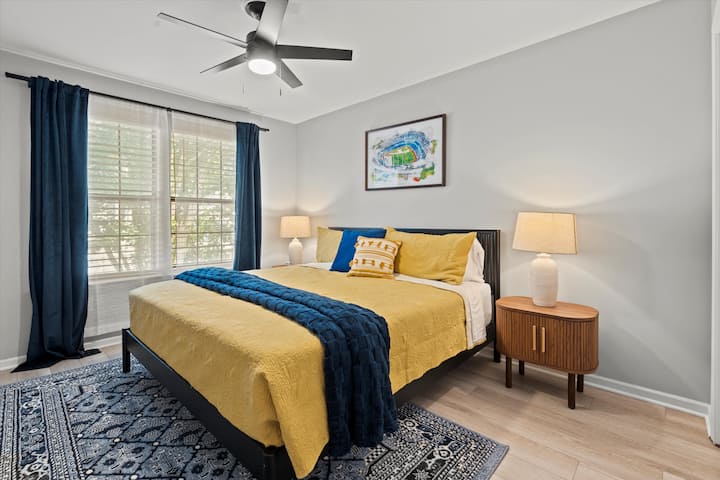 חדר שינה גדול ברמה השנייה עם מצעים נעימים, מאוורר תקרה ואור טבעי לשהייה רגועה ומרגיעה.