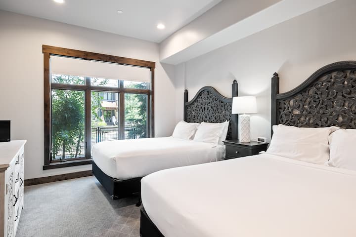 - Dormitorio de invitados con dos camas matrimoniales.  
- Elegantes cabeceros de madera tallada  
- Gran ventana con luz natural.