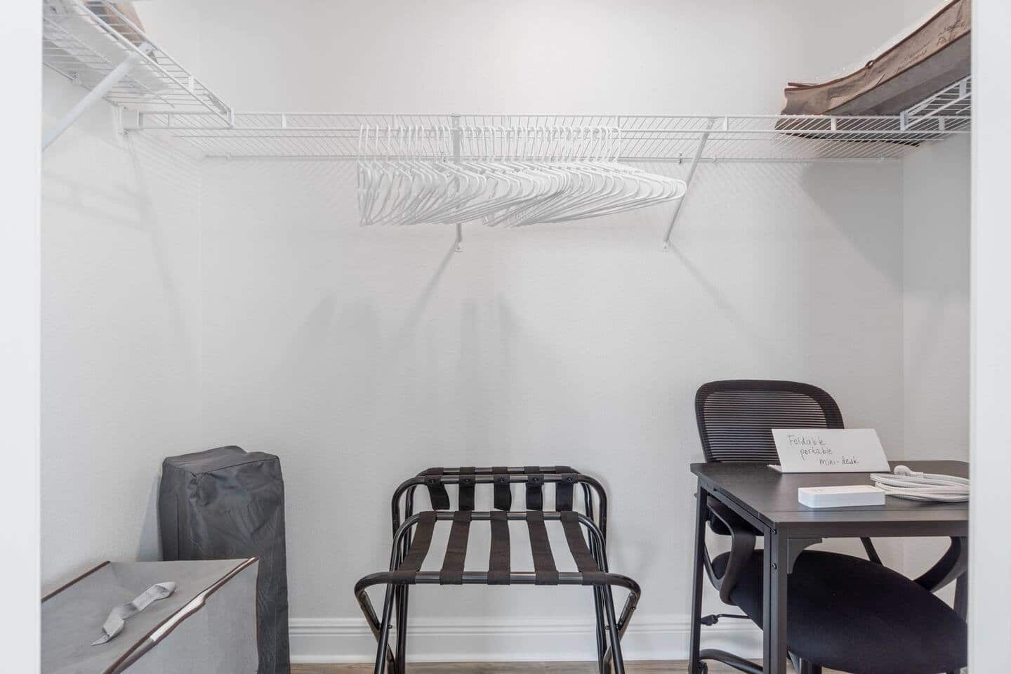 Walk-in closet: extra pillows, bedding, suitcase racks, Baby Trend Nursery Center Playard; a folding portable mini-desk and office chair…