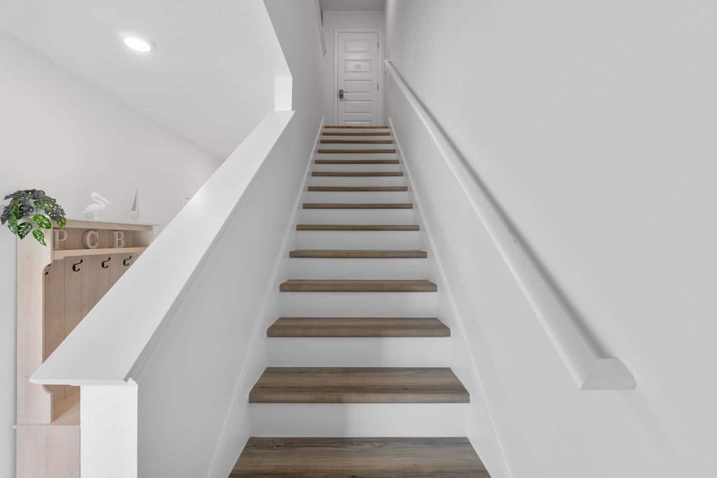Wide stairs to the second floor with spacious primary bedroom, guest bathroom, laundry room, and two smaller bedrooms with queen bed,…