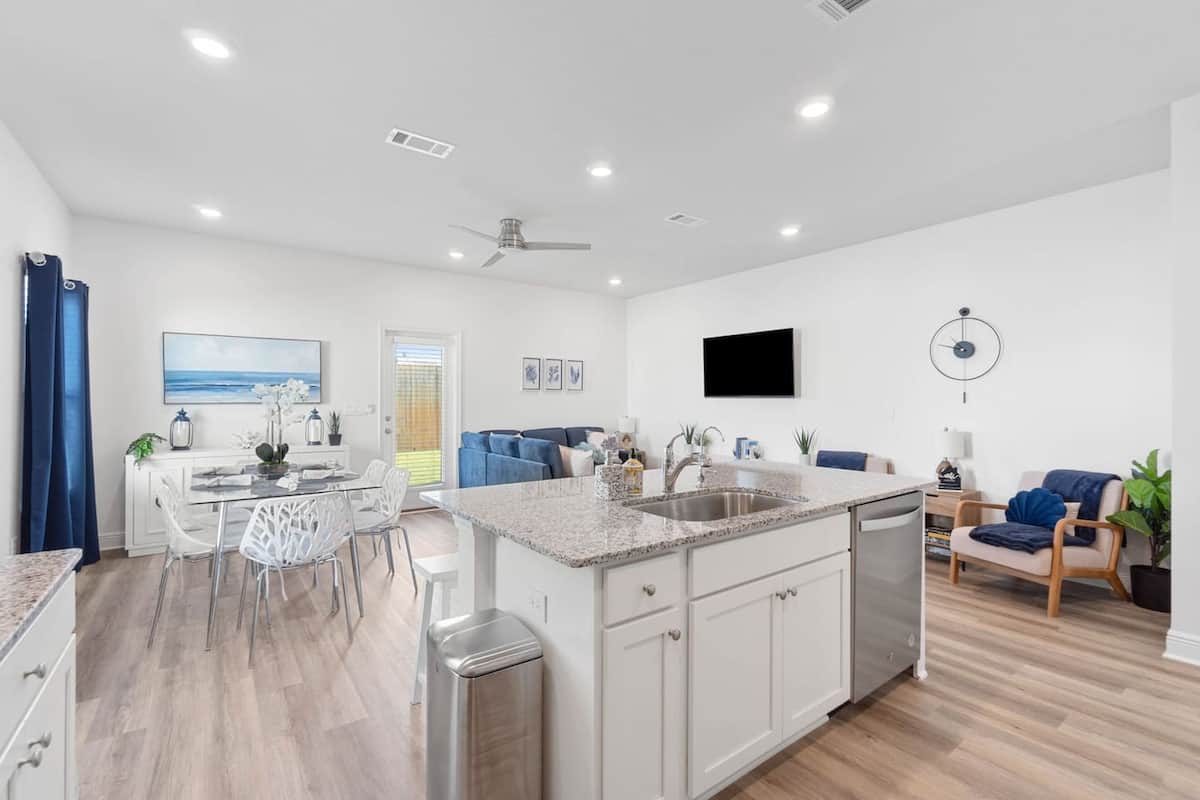 Relax in our charming open concept modern kitchen and living area, featuring large windows that invite abundant natural light throughout