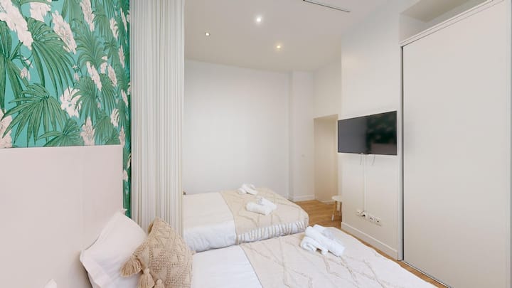 Room with two separate beds and TV