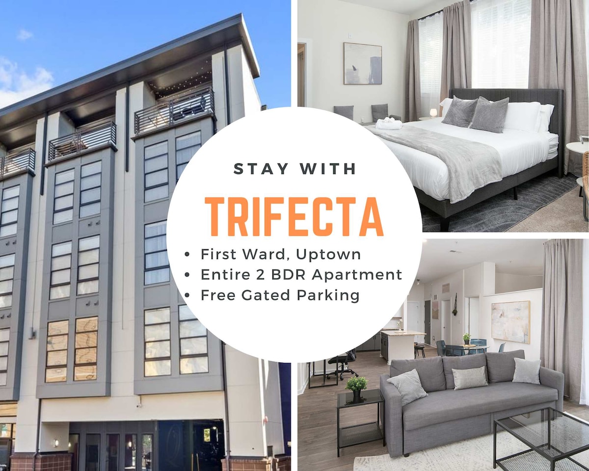 The exterior of the modern building reflects a sleek design, featuring large windows and a contemporary facade. Inside, a spacious bedroom showcases a neatly made bed with gray bedding. A comfortable sofa is visible in the living area, providing a cozy atmosphere for guests.
