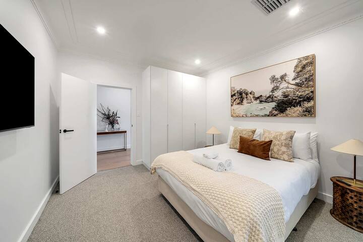 ผ่อนคลายในห้องนอนควีนไซส์ที่ซับซ้อนพร้อมทีวีและตู้ที่มีสไตล์ซึ่งความสะดวกสบายมาบรรจบกับการออกแบบร่วมสมัย